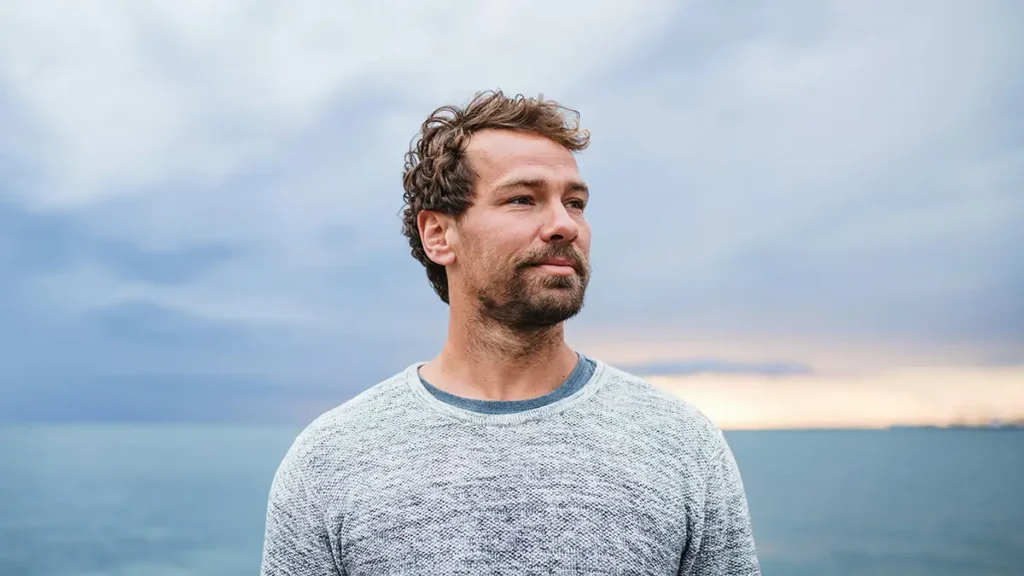 Homme regardant l'horizon face à la mer — reconstruction intérieure après un traumatisme, hypnothérapie en Touraine