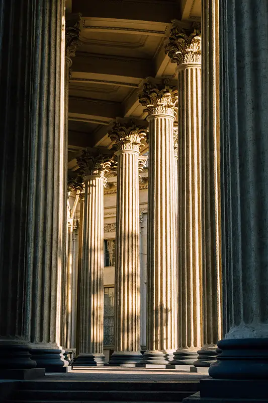 Colonnes corinthiennes dorées d'un temple antique dans une lumière oblique — symbole du temple intérieur et de la reconstruction psychique par l'hypnose, Touraine