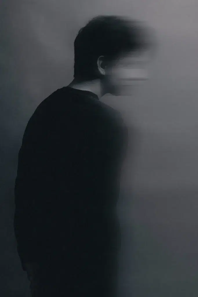 Silhouette en noir et blanc tête baissée, flou de mouvement — culpabilité du survivant et effondrement psychique après la guerre