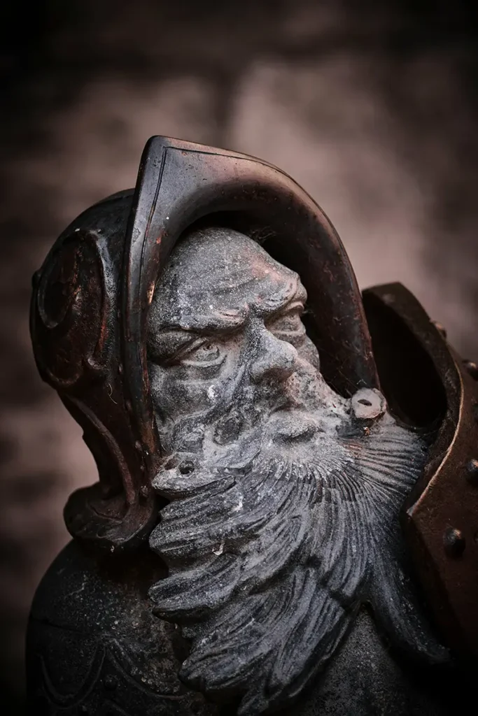 Statue de gardien ancien avec casque érodé par le temps, symbolisant le système d'alerte qui ne redescend jamais dans le stress chronique — hypnose Azay-le-Rideau