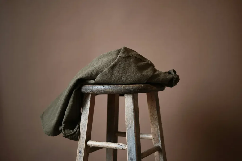 Vêtement déposé sur un tabouret en bois, symbolisant la honte et la culpabilité après agression sexuelle qu'on ne porte plus — hypnose Châtellerault