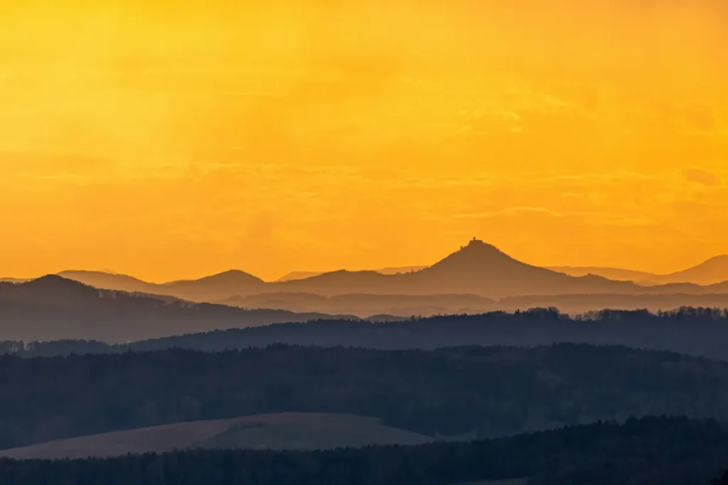 Ciel doré sur collines en silhouette — revenir à la vie après le deuil sans trahir ce qu'on a perdu