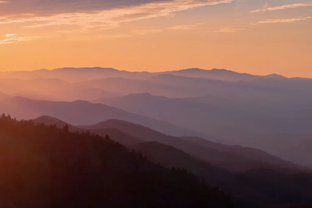 Couches de montagnes au lever du soleil, dégradé du sombre au doré — transformation identitaire dans le deuil