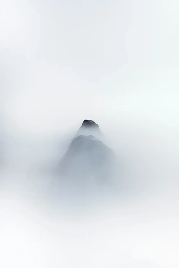 Sommet de montagne émergeant de la brume, symbolisant ce qui reste debout après la perte dans le travail du deuil, hypnose Azay-le-Rideau