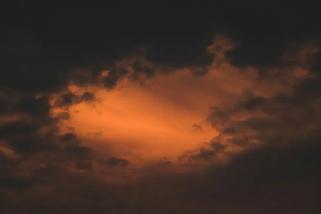Ciel nocturne oppressant avec lueur orange enfermée entre les nuages, hypnose spécialisée pour la violence conjugale à l'étranger sans réseau de soutien