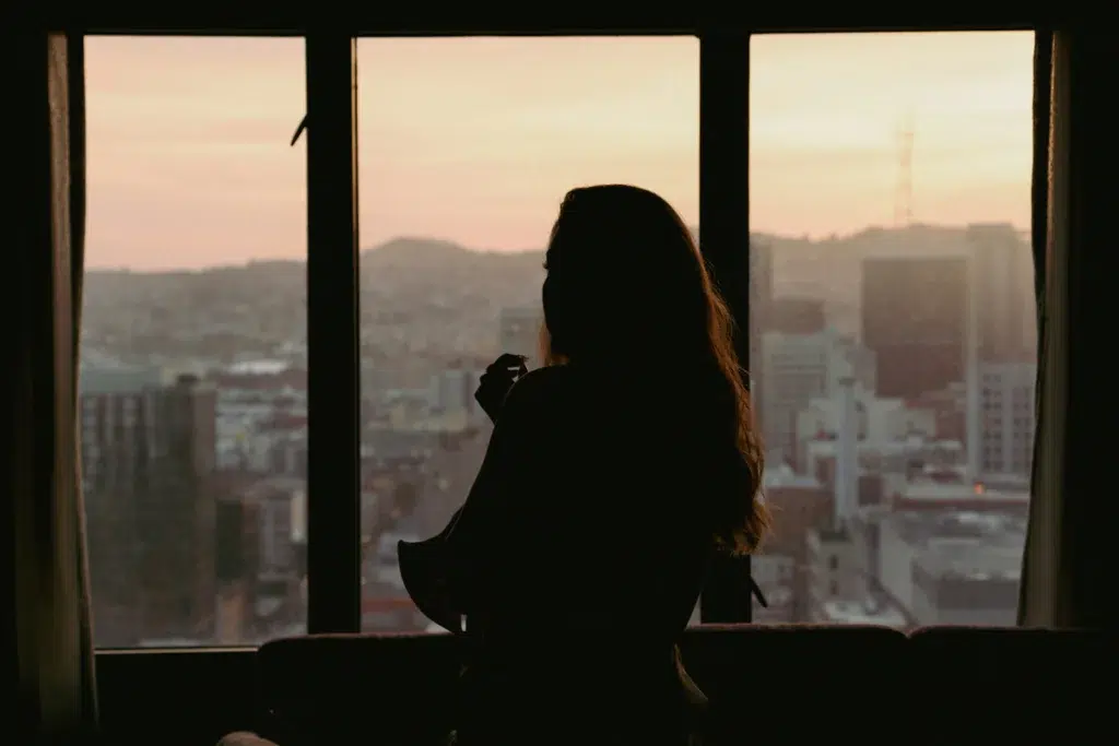 Femme de militaire regardant la ville au crépuscule, dans l'attente et l'angoisse d'une mission